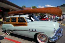 Rare 1951 Buick Super Estate Wagon woodie exhibited in a classic car show on a sunny summer day under blue skies
