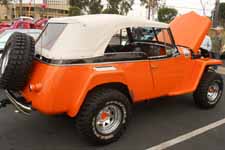 Striking orange and black paint job on a nicely up-graded vintage Willys Overland Jeepster