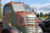 Heavy-duty GMC COE truck in vintage car wrecking yard