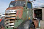 Rare GMC COE truck parked in classic car and truck salvage yard