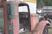 1936 Chevy tow truck parked at vintage car wrecking yard