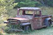 Original 1950's Willys Overland Jeep pickup truck in old car wreckingyard